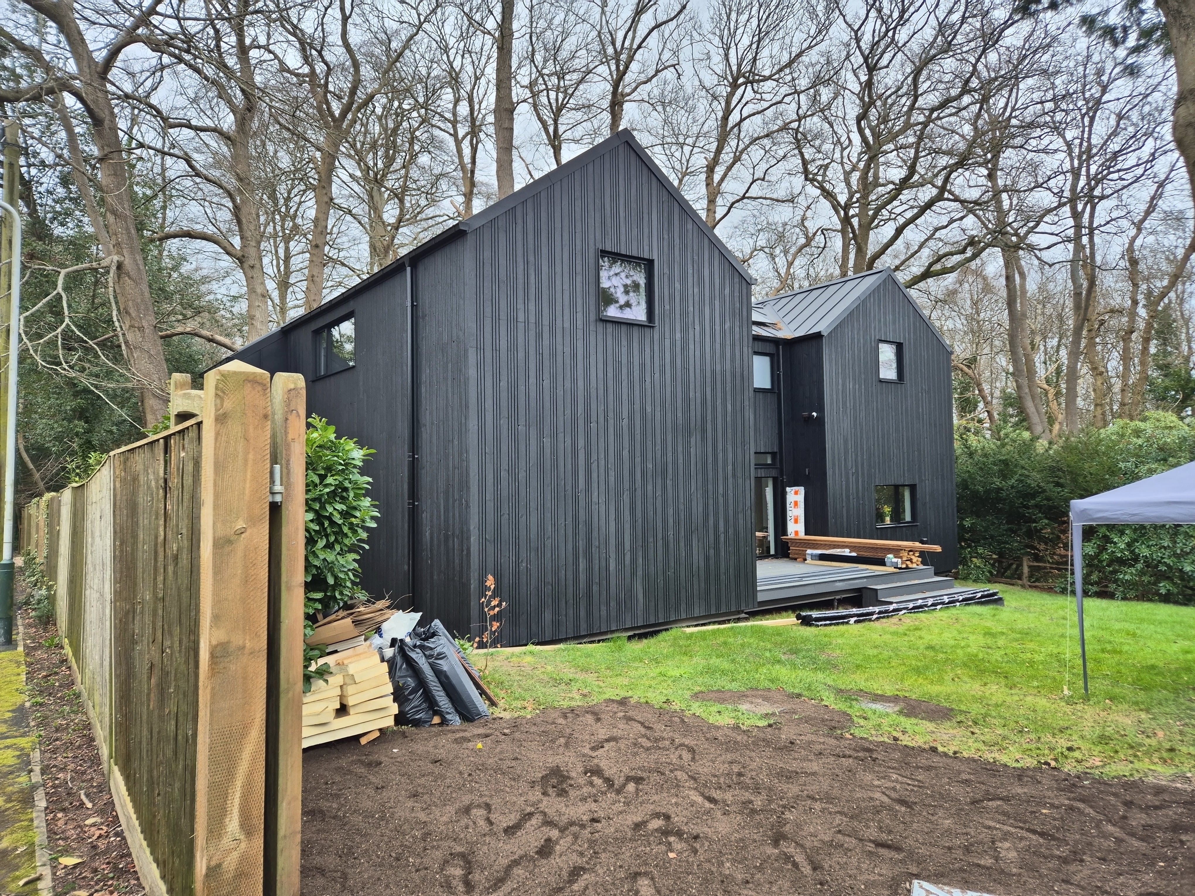 Rear elevation of black timber-clad house under construction, Woodland House, Tunbridge Wells TN2 — 360 Measurements